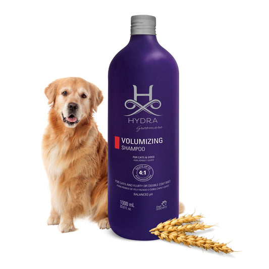 Hydra Groomer’s Volumizing Pet Shampoo bottle with fluffy dog breeds background